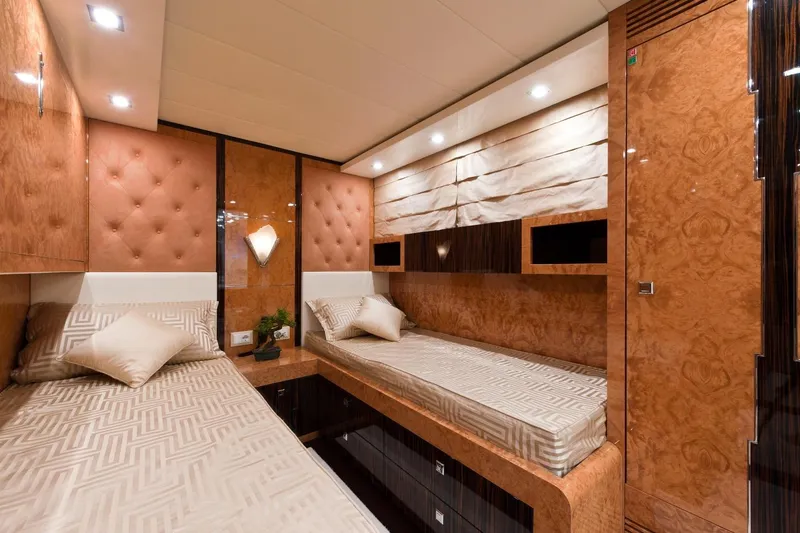  Yacht Photos Pics Luxurious twin cabin interior on 2009 Maiora 32 yacht, featuring elegant wood paneling and plush bedding.