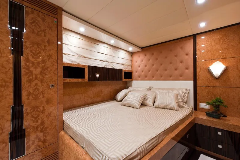  Yacht Photos Pics Luxurious bedroom interior on 2009 Maiora 32 yacht, featuring elegant wood paneling and plush bedding.