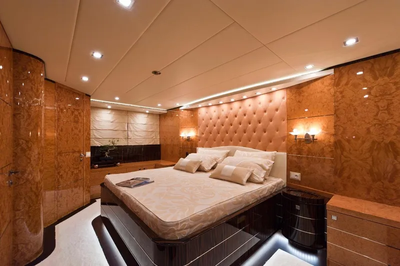  Yacht Photos Pics Luxurious bedroom interior on 2009 Maiora 32 yacht, featuring elegant wood paneling and ambient lighting.