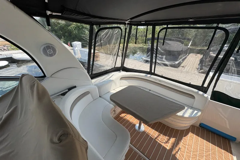  Yacht Photos Pics 2005 Sea Ray 340 Sundancer interior with seating and table, docked by the water.