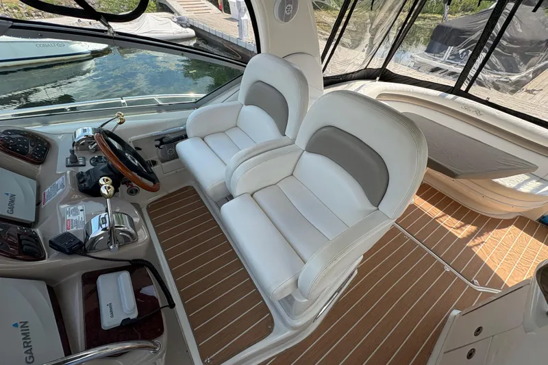  Yacht Photos Pics 2005 Sea Ray 340 Sundancer cockpit with dual white seats and wooden flooring.