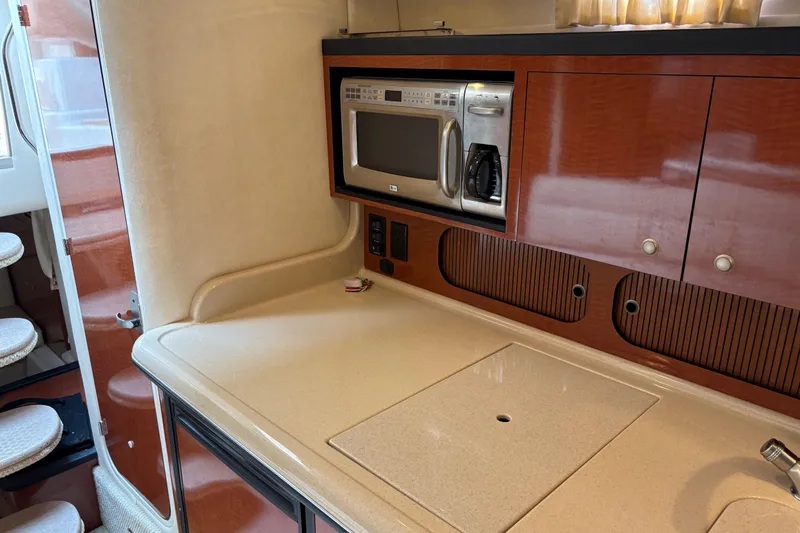  Yacht Photos Pics 2005 Sea Ray 340 Sundancer kitchen with microwave and wooden cabinetry.