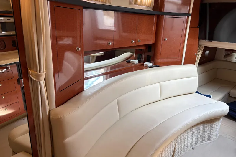  Yacht Photos Pics Luxurious interior of 2005 Sea Ray 340 Sundancer with curved leather seating and wooden cabinetry.