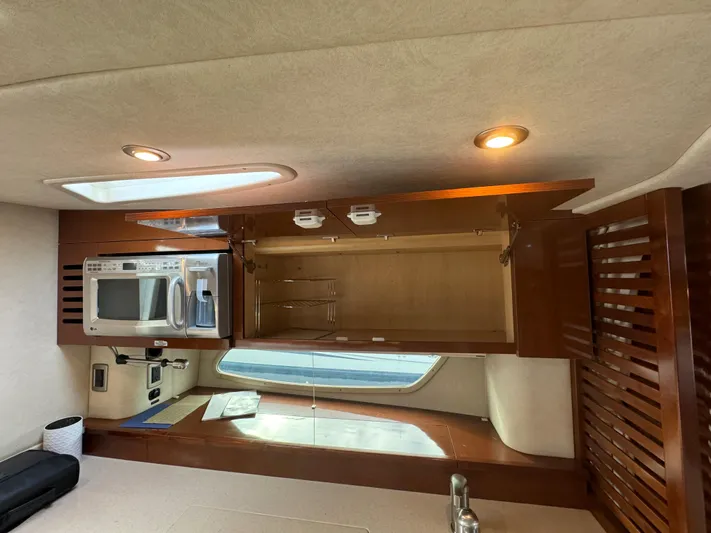 Pendragon Yacht Photos Pics Interior of 2009 Sea Ray 350 Sundancer with open cabinet, microwave, and window.