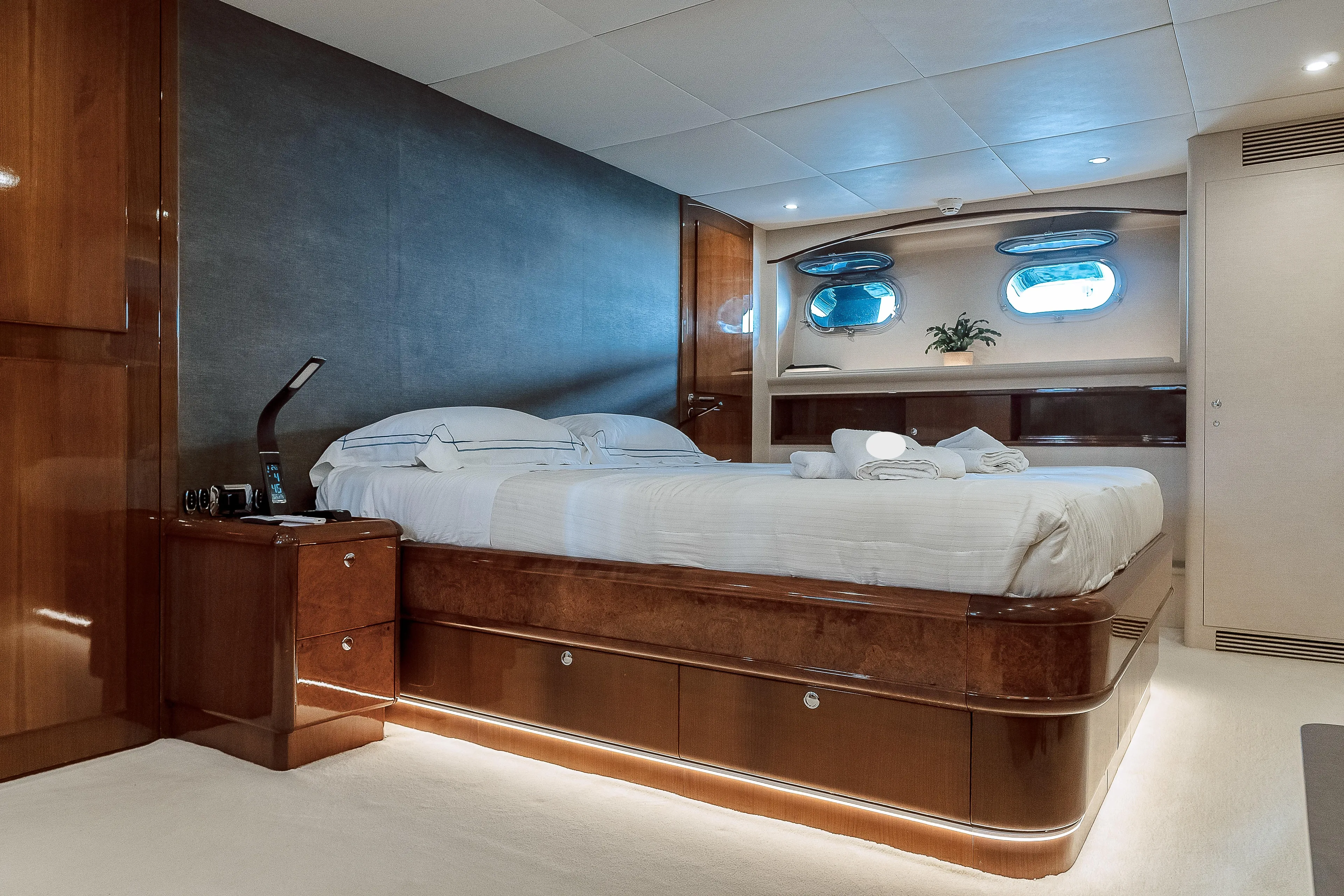Theion Yacht Photos Pics Luxurious bedroom interior on a 1997 Baglietto 31m yacht, featuring elegant wood finishes.