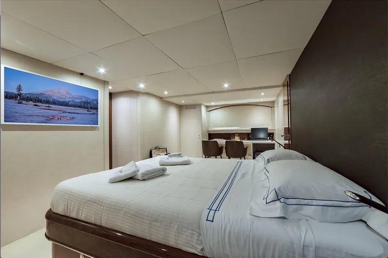 Theion Yacht Photos Pics Luxurious bedroom interior on 1997 Baglietto 31m yacht with modern decor and cozy ambiance.