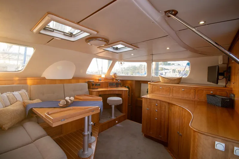 Amazing Grace Yacht Photos Pics Luxurious interior of 2004 Antares PDQ 44 yacht with wooden cabinetry and seating area.