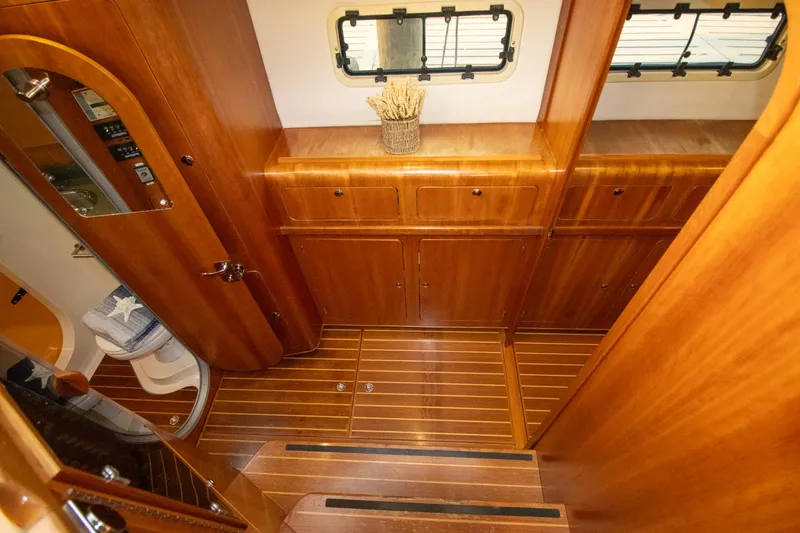 Amazing Grace Yacht Photos Pics Luxurious wooden interior of 2004 Antares PDQ 44 yacht with cabinets and porthole windows.