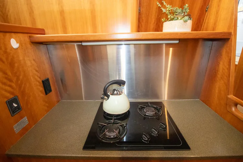 Amazing Grace Yacht Photos Pics Compact kitchen in 2004 Antares PDQ 44 yacht with stove and kettle.