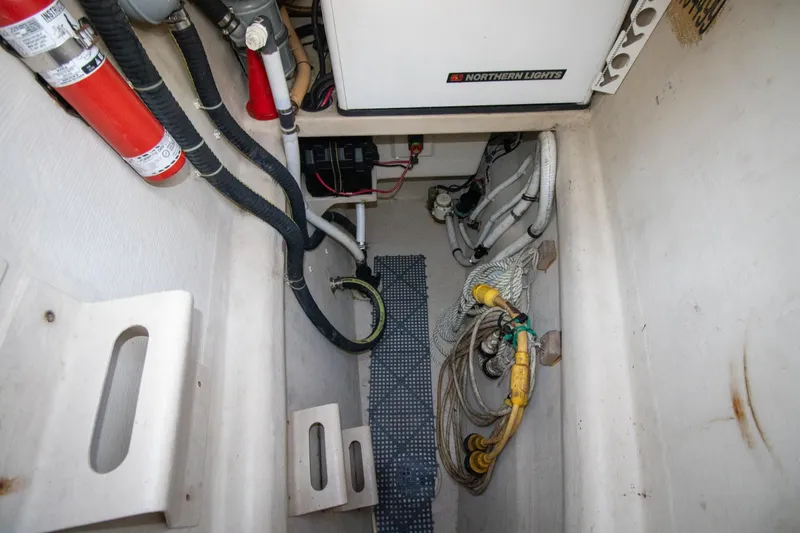 Amazing Grace Yacht Photos Pics Engine compartment of 2004 Antares PDQ 44 with wiring, hoses, and fire extinguisher.