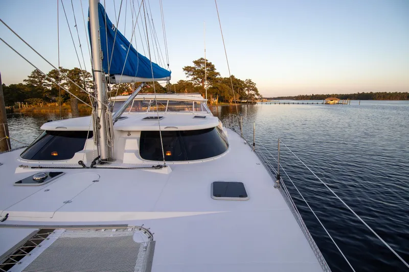 Amazing Grace Yacht Photos Pics Sailing catamaran Antares PDQ 44, 2004 model, on calm waters at sunset.
