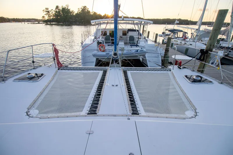 Amazing Grace Yacht Photos Pics 2004 Antares PDQ 44 catamaran docked at sunset, featuring spacious deck and netting.