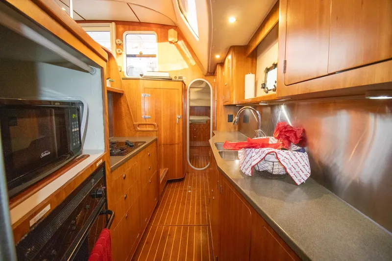 Amazing Grace Yacht Photos Pics Luxurious 2004 Antares PDQ 44 yacht kitchen with wood cabinetry and modern appliances.