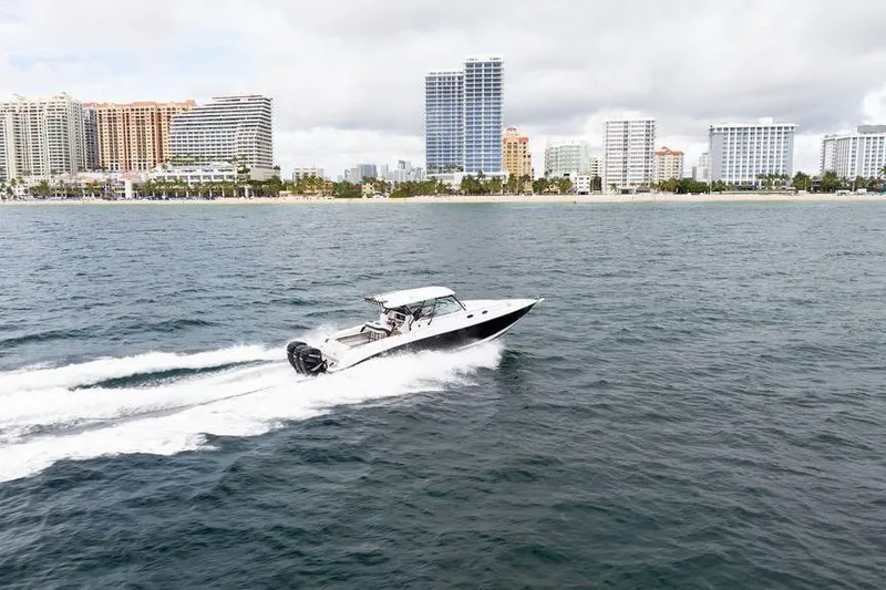  Yacht Photos Pics 2008 Donzi 38 ZSF boat cruising near a city skyline on a cloudy day.