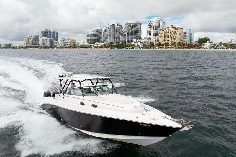  Yacht Photos Pics 2008 Donzi 38 ZSF boat cruising near city skyline on a cloudy day.
