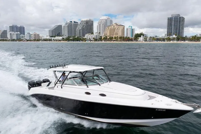  Yacht Photos Pics 2008 Donzi 38 ZSF boat cruising near a city skyline on a cloudy day.