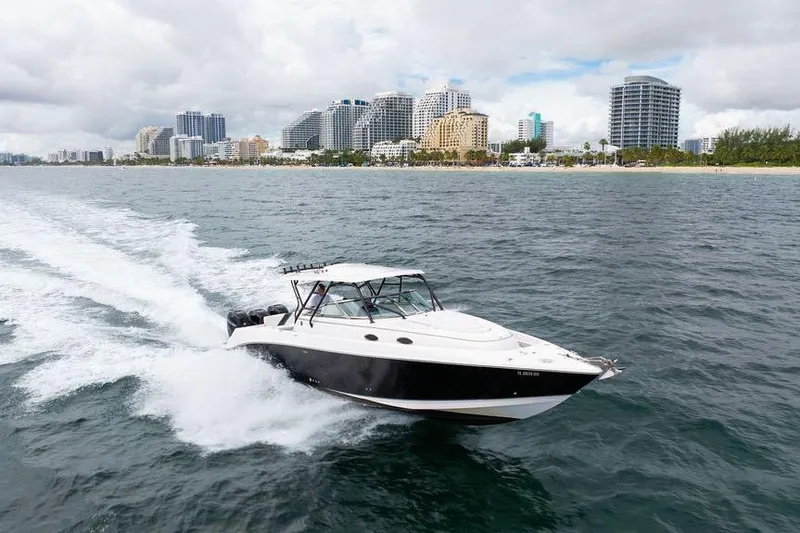  Yacht Photos Pics 2008 Donzi 38 ZSF boat cruising near a city skyline on a cloudy day.