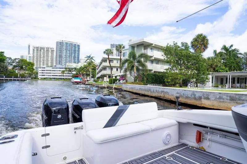  Yacht Photos Pics 2008 Donzi 38 ZSF boat cruising in a scenic urban waterway with buildings and palm trees.