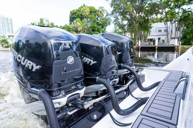  Yacht Photos Pics Triple Mercury outboard engines on a 2008 Donzi 38 ZSF boat, docked by a waterfront home.