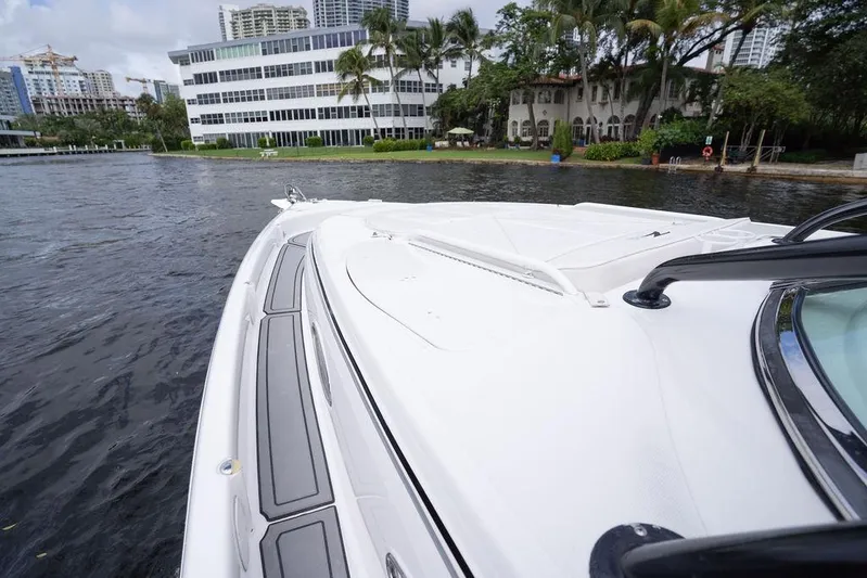  Yacht Photos Pics 2008 Donzi 38 ZSF boat cruising near waterfront buildings and lush greenery.