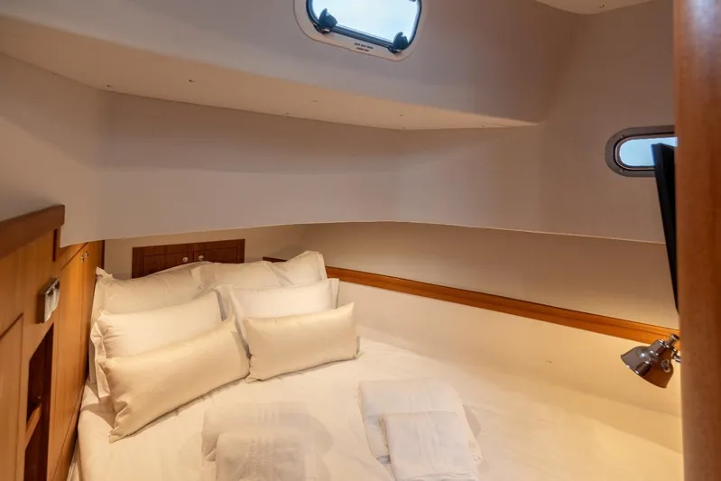 Gala Yacht Photos Pics Cozy cabin interior of 2019 Targa 46 yacht with plush bedding and porthole windows.