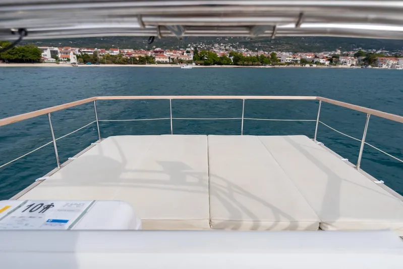 Gala Yacht Photos Pics Luxury Targa 46 yacht deck with sunbeds, overlooking serene coastal town, 2019 model.