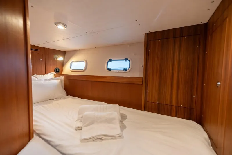 Gala Yacht Photos Pics Cozy cabin interior of 2019 Targa 46 yacht with wooden paneling and porthole windows.