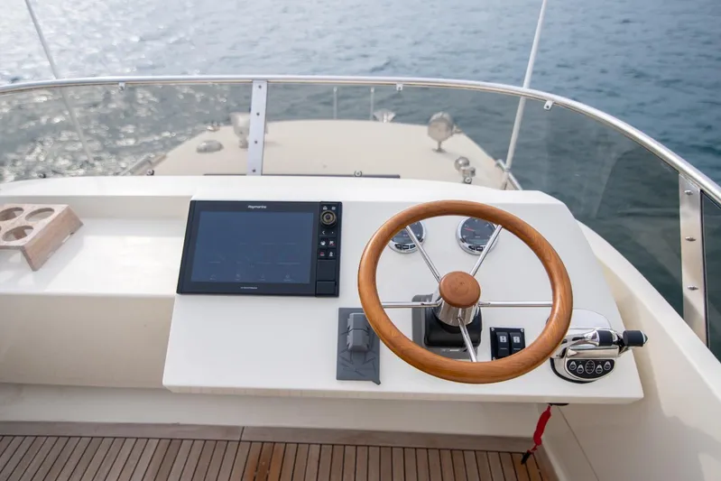Gala Yacht Photos Pics Steering wheel and controls of a 2019 Targa 46 boat, overlooking the water.