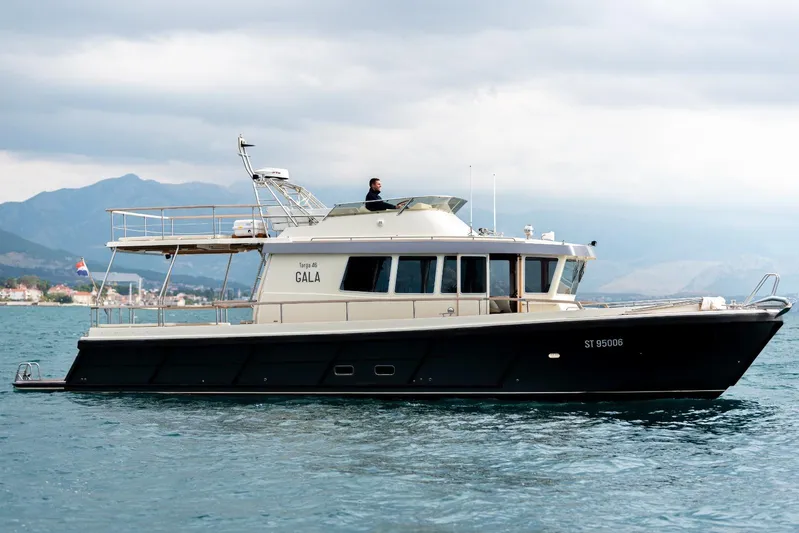 Gala Yacht Photos Pics Targa 46 yacht cruising on water, 2019 model, with scenic mountain backdrop.