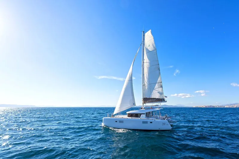 K3 Yacht Photos Pics 2019 Lagoon 50 sailing catamaran on open sea under clear blue sky.