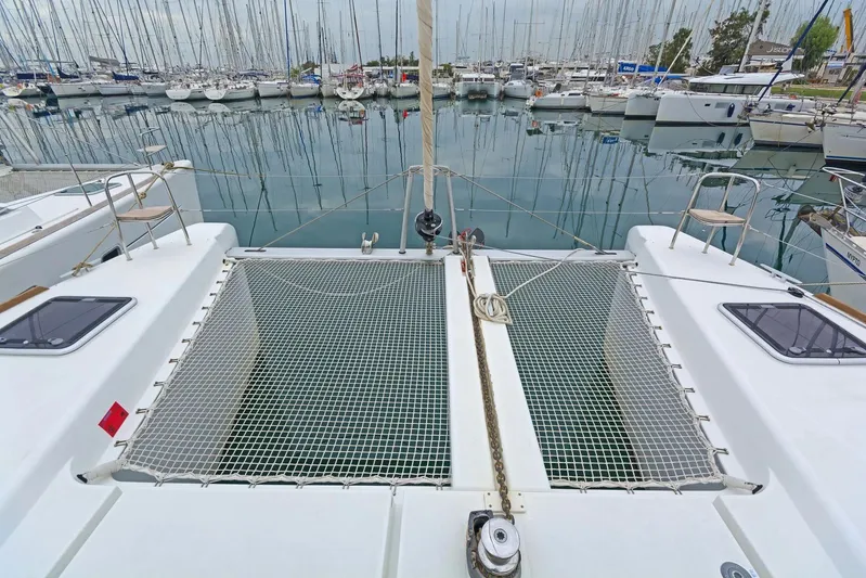 K3 Yacht Photos Pics 2019 Lagoon 50 catamaran docked in a marina, showcasing spacious deck and netting.