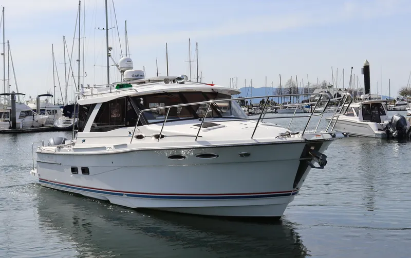 The Islander Yacht Photos Pics 2018 Cutwater C-302 Coupe boat docked in a marina, surrounded by other vessels.