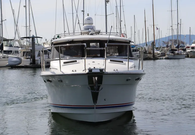 The Islander Yacht Photos Pics 2018 Cutwater C-302 Coupe boat docked in a marina, surrounded by sailboats.