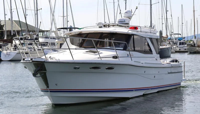 The Islander Yacht Photos Pics 2018 Cutwater C-302 Coupe boat docked in a marina with sailboats in the background.