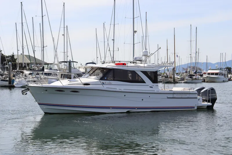 The Islander Yacht Photos Pics 2018 Cutwater C-302 Coupe boat docked in a marina with sailboats.