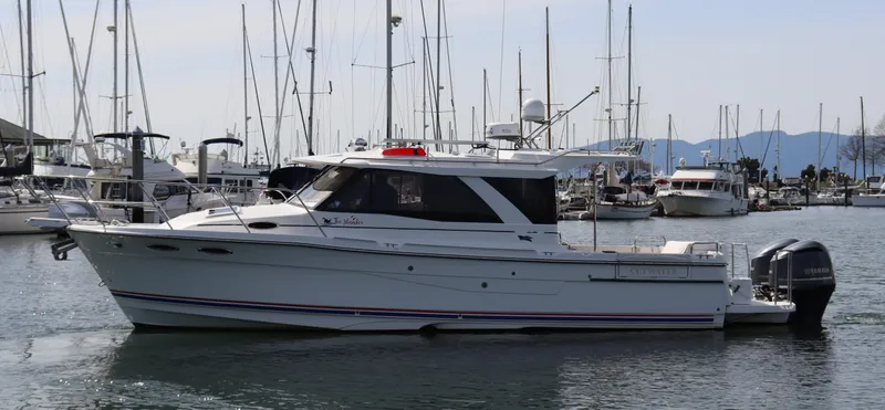 The Islander Yacht Photos Pics 2018 Cutwater C-302 Coupe boat docked in a marina with sailboats in the background.