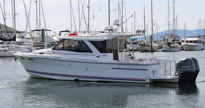 The Islander Yacht Photos Pics 2018 Cutwater C-302 Coupe boat docked in a marina, surrounded by other vessels.