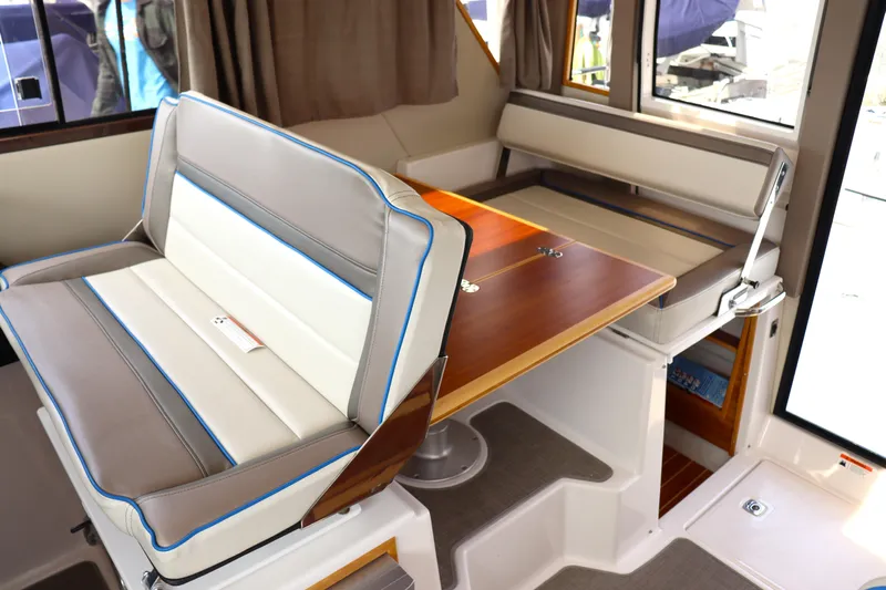 The Islander Yacht Photos Pics 2018 Cutwater C-302 Coupe interior with convertible seating and wooden table.