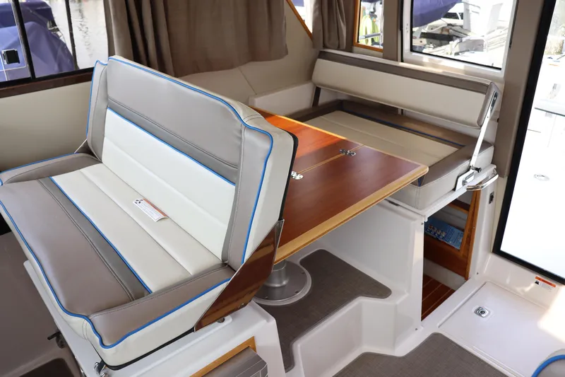 The Islander Yacht Photos Pics 2018 Cutwater C-302 Coupe interior with convertible seating and wooden table.
