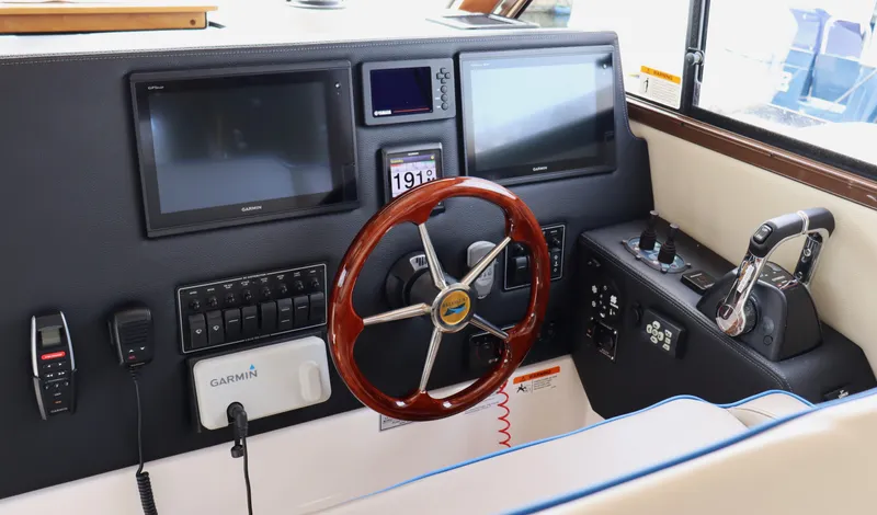 The Islander Yacht Photos Pics 2018 Cutwater C-302 Coupe helm with dual screens and wooden steering wheel.