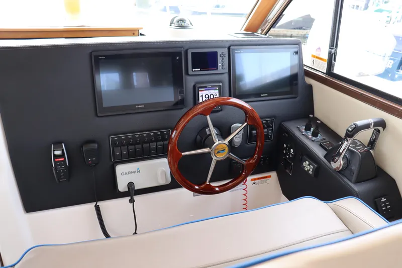 The Islander Yacht Photos Pics 2018 Cutwater C-302 Coupe helm with dual screens, wooden steering wheel, and navigation controls.