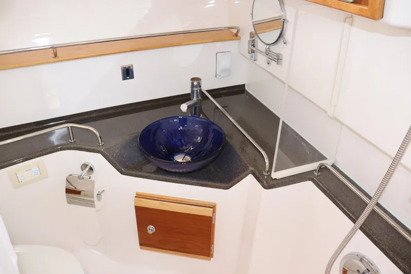 The Islander Yacht Photos Pics 2018 Cutwater C-302 Coupe bathroom with blue sink, modern fixtures, and compact design.