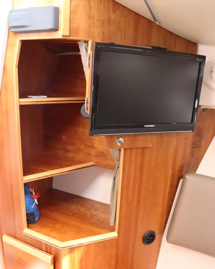 The Islander Yacht Photos Pics 2018 Cutwater C-302 Coupe interior with wooden shelves and mounted TV.