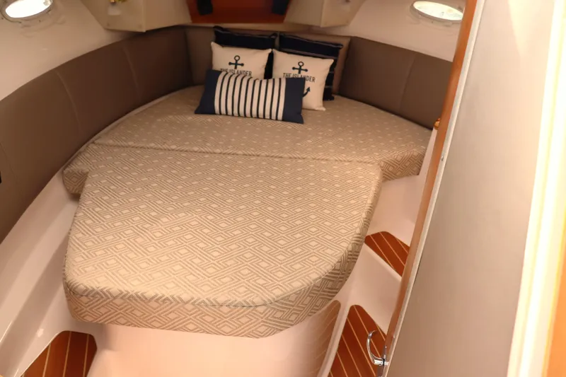 The Islander Yacht Photos Pics 2018 Cutwater C-302 Coupe cabin with cozy bed and nautical-themed pillows.