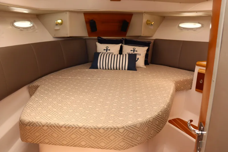 The Islander Yacht Photos Pics 2018 Cutwater C-302 Coupe cabin with cozy bed and nautical-themed pillows.