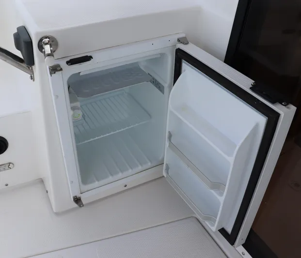 The Islander Yacht Photos Pics Open refrigerator on 2018 Cutwater C-302 Coupe boat, showcasing interior storage space.