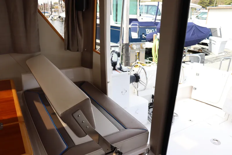 The Islander Yacht Photos Pics Interior view of 2018 Cutwater C-302 Coupe, showcasing seating and marina background.
