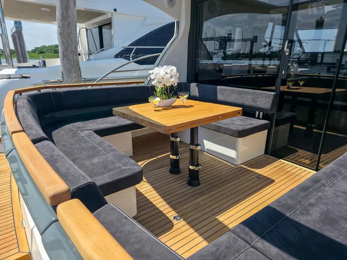 Yacht Photos Pics Luxurious seating area on 2026 Marex 440 yacht with wooden table and elegant decor.