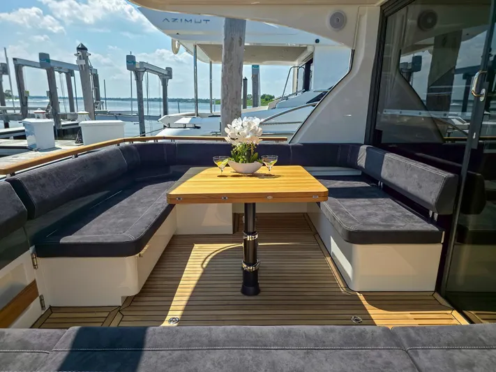  Yacht Photos Pics Luxurious seating area on 2026 Marex 440 yacht with wooden table and floral centerpiece.