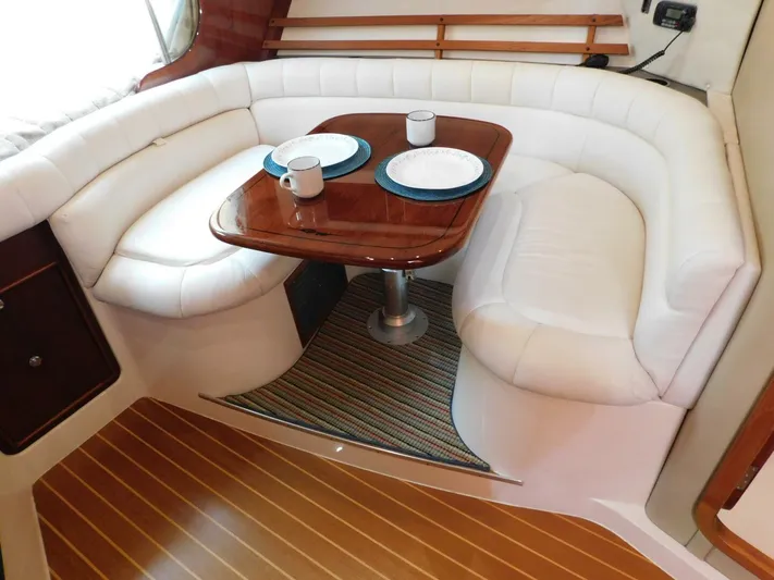  Yacht Photos Pics Luxurious seating area in 2008 Grady-White Express 360 boat with wooden table and white cushions.